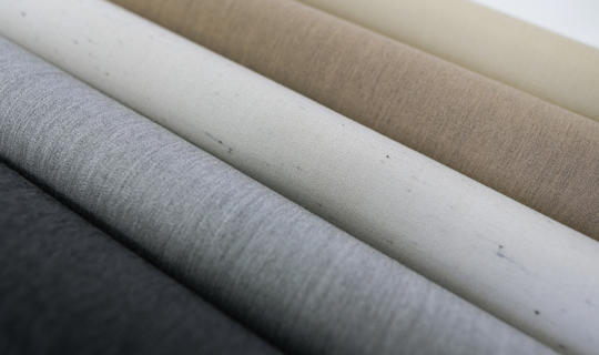 Različni vzorci in barve visokokakovostnih tkanin za tende – od temno sive do svetlo bež odtenkov.