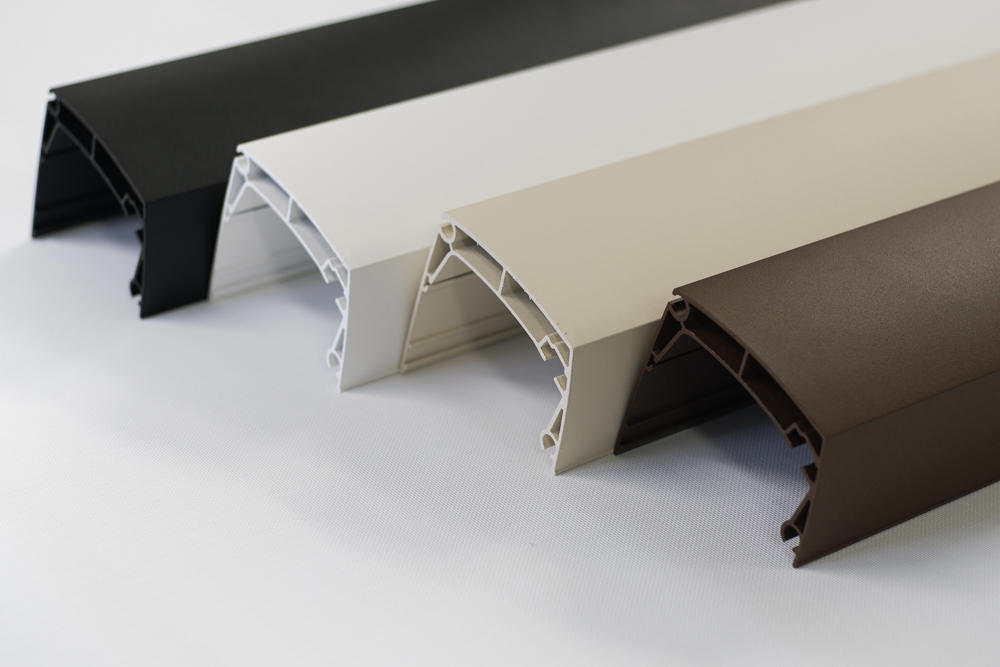 Barvni vzorci aluminijastih profilov za senčila – črna, bela, bež in rjava – prikazani na beli podlagi.